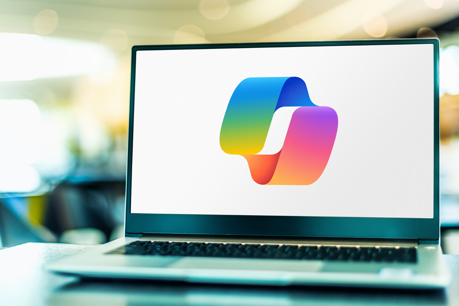 Laptop with the rainbow colored Microsoft Copilot logo.